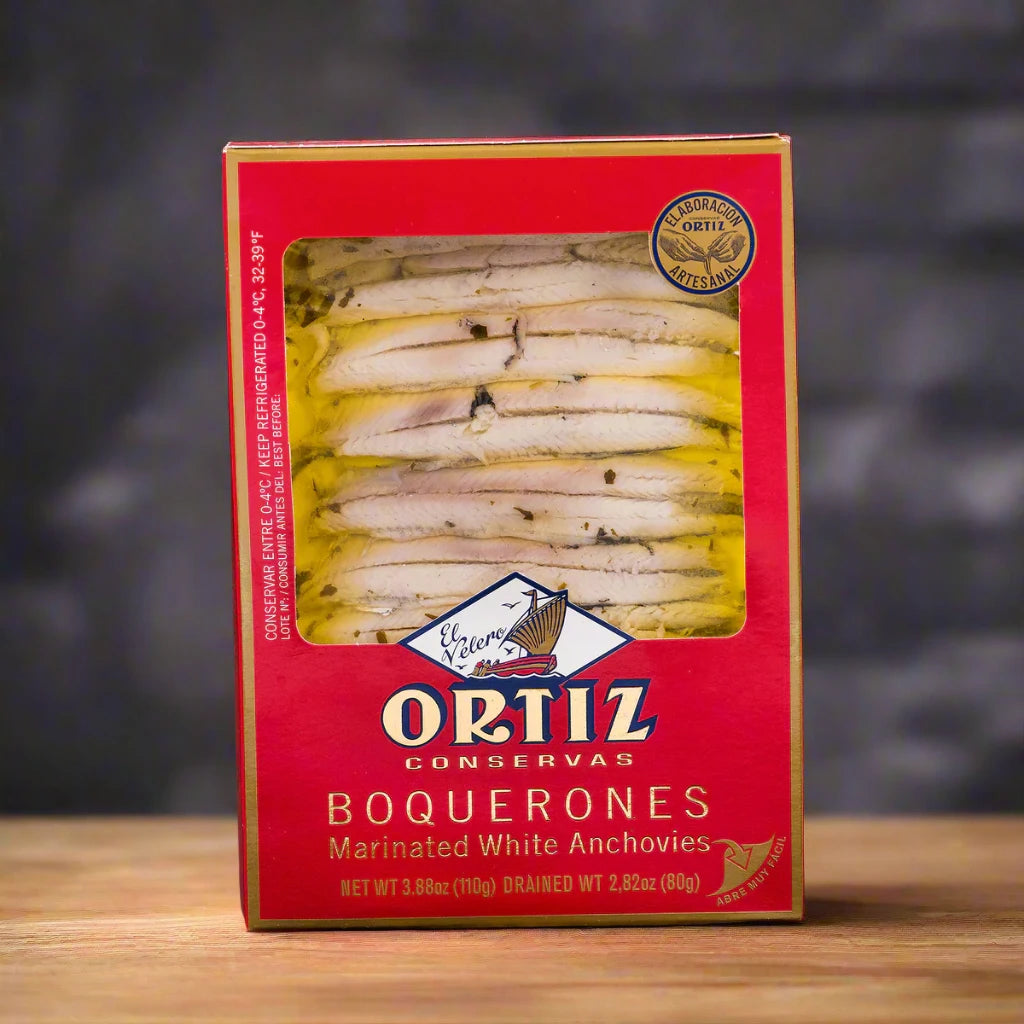 red retail packaging of boquerones (white anchovies) in marinated olive oil and herbs