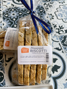 lemon pistachio biscotti, 5 pieces, inside of clear retail bag, with blue/gold ribbon tied.