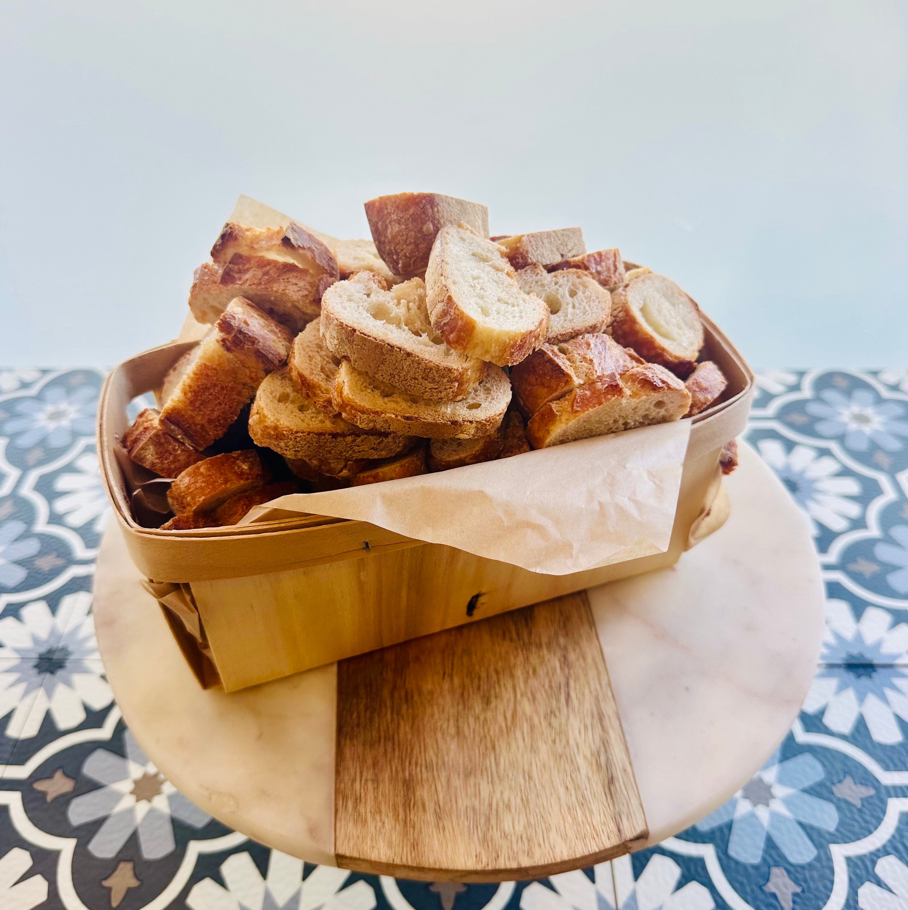 a wooden basket with sliced baguette