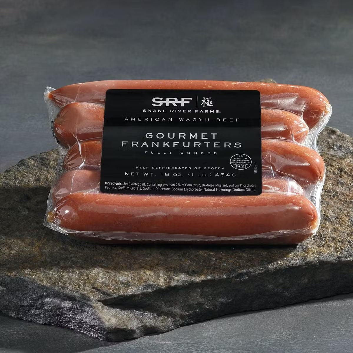plastic package of five hotdogs on a rock